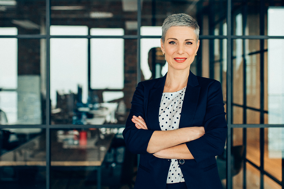 Proud CIO standing in front of boardroom after a successful meeting where she led the conversation about energy efficiency.
