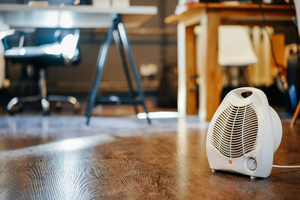 A space heater under a desk. Space heaters may spell inefficient heating.