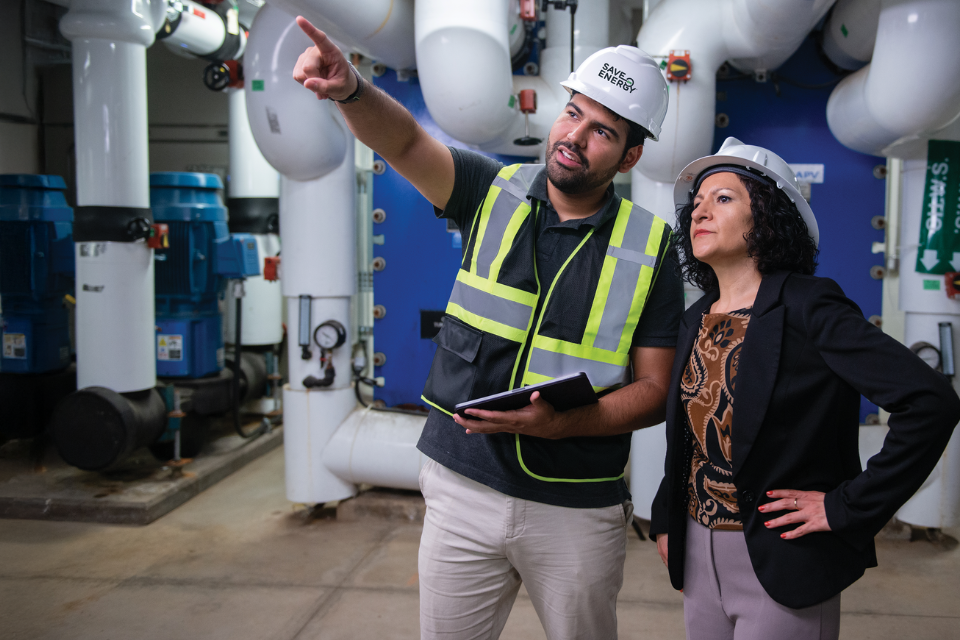 Two people examining industrial equipment